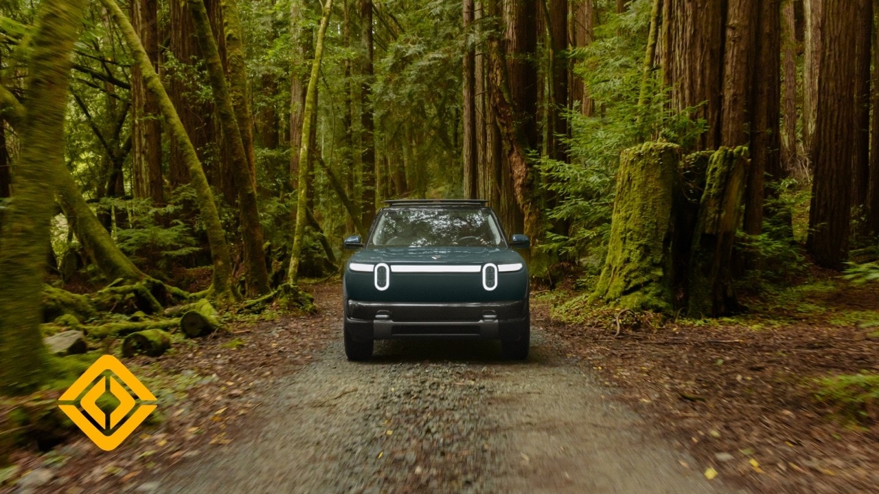 Rivian R2 driving along a forest road
